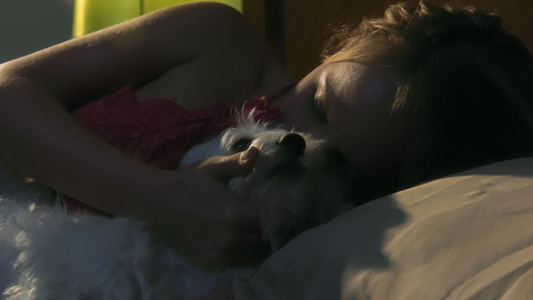  年轻的女人躺在床上抚摸她的宠物狗视频
