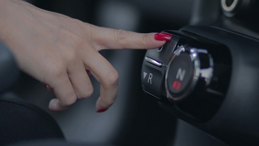 女性的手指按下汽车仪表板上变速箱驱动按钮特写[女同胞]视频