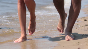 一对夫妇在海边散步的特写在沙滩上留下脚印17秒视频