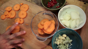 女人的手在玻璃碗里加入胡萝卜切片13秒视频