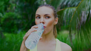 年轻漂亮的金发女郎跑步后喝水享受美丽的夏日9秒视频