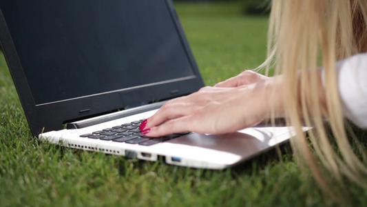 女商人用笔记本电脑在绿色草坪上办公视频