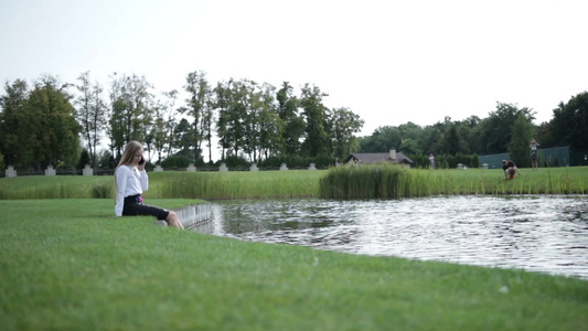 坐在湖边泡脚的女人视频