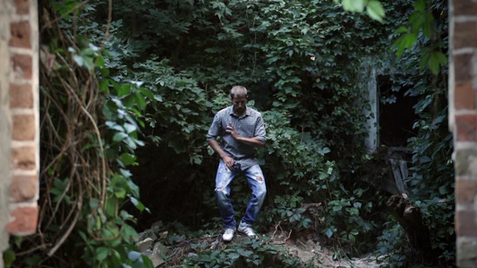 年轻男子在户外的绿树和植物背景下跳舞视频