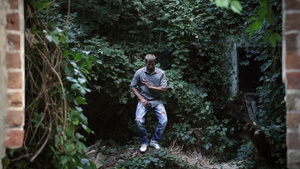 年轻男子在户外的绿树和植物背景下跳舞47秒视频