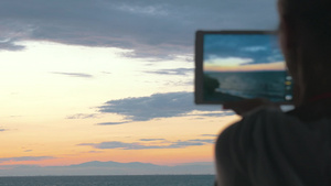 女人平板电脑拍摄日落14秒视频