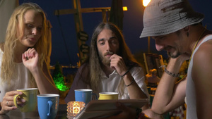 晚上在街上喝茶的男女在讨论平板电脑上的信息16秒视频
