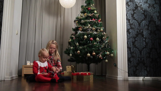 圣诞节两个小朋友坐在地上玩玩具视频