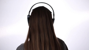 背面的年轻女子戴上耳机听音乐14秒视频