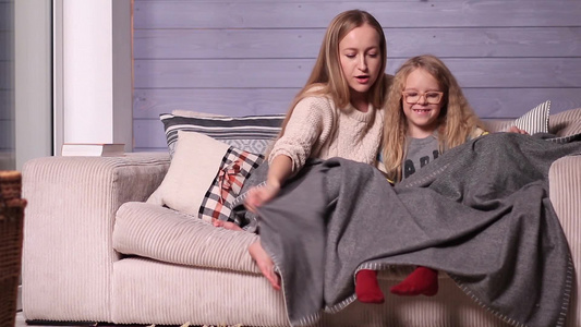 母女俩裹着毯子窝在沙发里视频