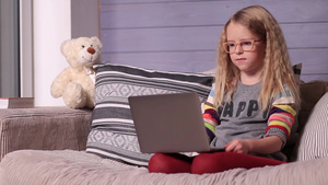 小女孩坐在沙发上看电脑22秒视频