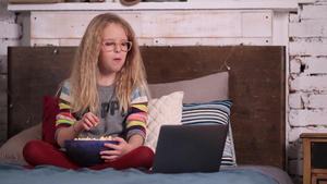 小女孩吃着爆米花看电脑19秒视频