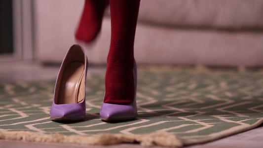 孩子的小脚穿着母亲的高跟鞋在家里跳舞视频