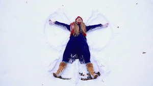 年轻快乐的女人躺在雪地上20秒视频