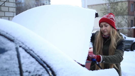 女人打开汽车后备箱拿出雪刷打扫她的汽车视频