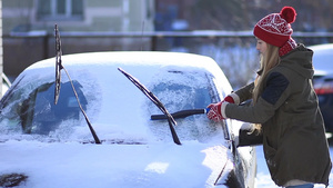 女孩在冬天用塑料雪刷清洗汽车前挡风玻璃42秒视频