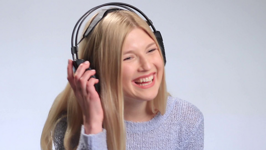 年轻女人戴着耳机享受音乐视频