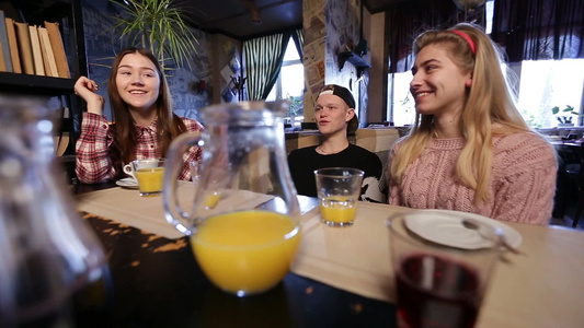 年轻男女在咖啡店喝咖啡和果汁视频