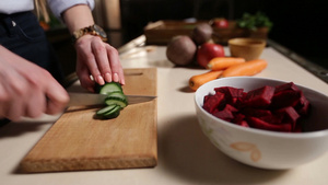 在厨房的木制砧板上用刀切黄瓜准备健康的蔬菜冰沙特写女性的手12秒视频