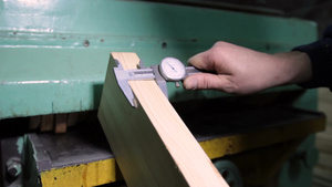  在车间工作的木工用卡尺测量木板的过程特写12秒视频