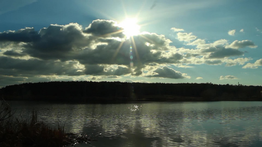 阳光透过云层照射到湖面视频