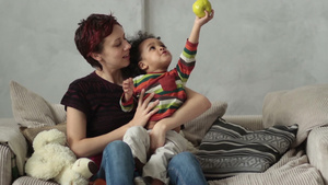 母亲和小男孩坐在沙发上玩耍53秒视频