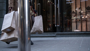 穿高跟鞋的女性携带购物袋走在街上13秒视频