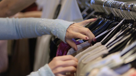 女人在商店挑选衣架上的衣服视频