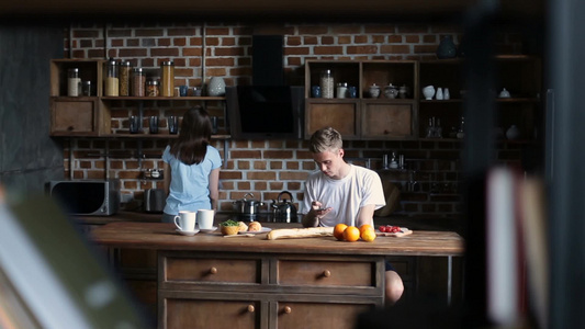 年轻夫妇在厨房里一起吃早餐丈夫和妻子一起分享有趣的事视频