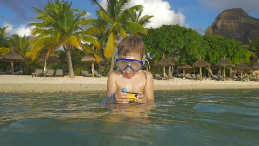 儿童在海里洗澡在浮潜中用防水相机玩耍慢视频