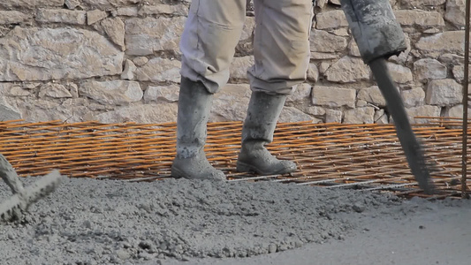 建筑工在使用混凝土浇筑压实液体水泥视频