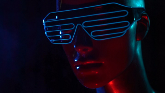 女性模特在蓝色发光的LED眼镜在黑暗的烟雾背景下的特写脸视频