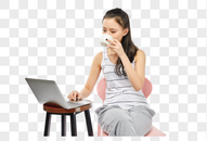 青年女性喝着咖啡使用电脑办公图片