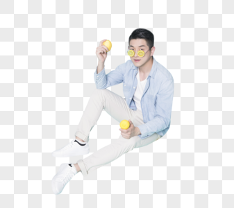 坐在地上拿着柠檬的青年男性图片