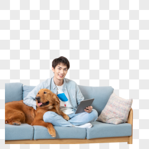 在沙发上抱着宠物拿着平板电脑的男孩图片