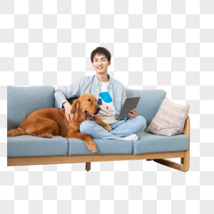 在沙发使用平板电脑的男孩与狗相伴图片