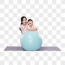 靠在瑜伽球上欢笑的母女图片