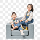 儿童双胞胎小女孩坐沙发上玩小鸭子玩具图片