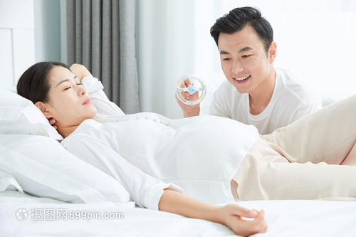 准爸爸和孕妇老婆玩婴儿玩具