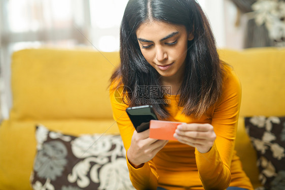 波斯女人用智能手机网上购物,用信用卡付款女人用智能手机购物,用她的信用卡付款图片