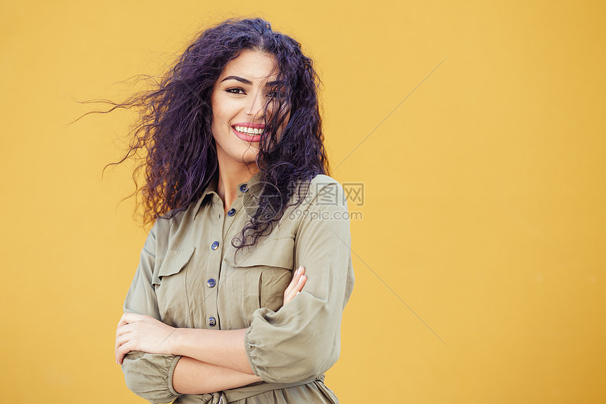城市背景中卷发的有趣的阿拉伯女人年轻的阿拉伯女人,卷发户外图片