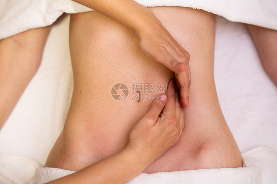 理疗中心接受腹部按摩的妇女图片