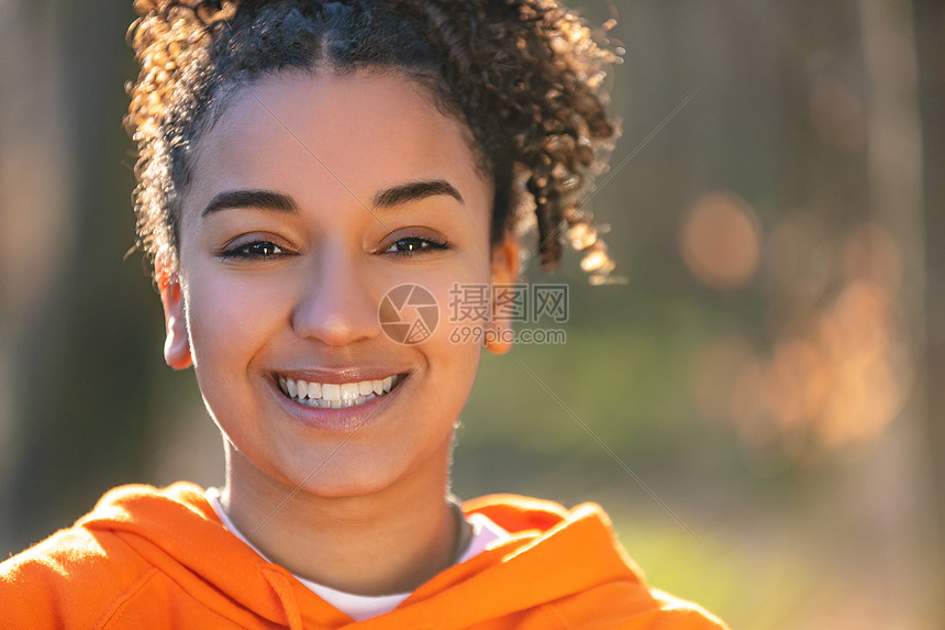 户外肖像美丽的快乐混合种族非裔美国女孩十几岁的女性年轻女子微笑与完美的牙齿金色的傍晚阳光图片