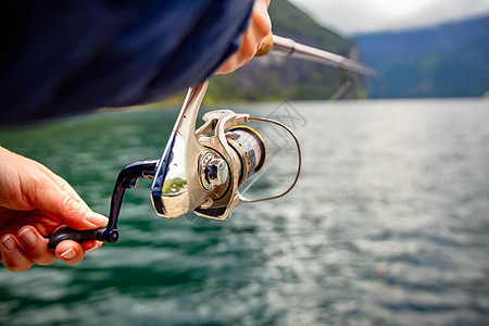 挪威钓鱼的女人钓鱼竿上挪威钓鱼拥抱当地生活方式的种方式无数的湖泊河流广阔的海岸线意味着杰出的机会图片