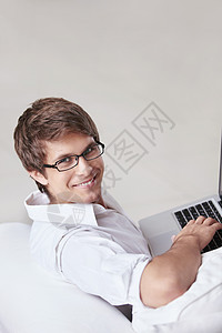个戴眼镜的年轻人带着笔记本电脑图片