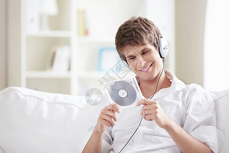 个带着耳机音乐CD的年轻人手中图片