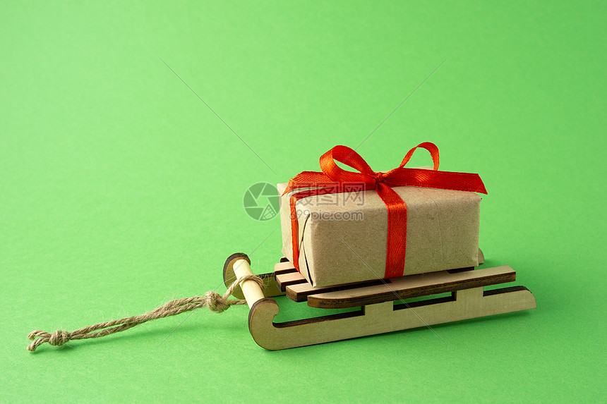 创意静物圣诞假期照片雪橇与礼物盒绿色背景图片