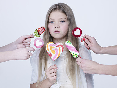 小漂亮的女孩带着大糖果工作室阿什翁摄影的孩子穿着白色连衣裙吃甜棒棒糖的美女模特图片