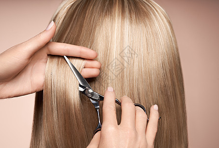 理发师用剪刀剪长金发发廊,发型师护理美容美发产品染了头发背景图片