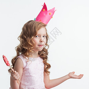 美丽的小糖果公主女孩戴着大棒糖,双手举空中说,为什么,知道,所以什么孤立白色的背景上困惑的糖果公主背景图片